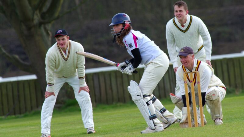 Pessoas jogando cricket para incentivar o jogador de cricketer